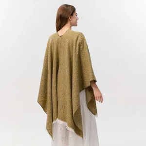 Details des ingwerfarbenen Strickschals mit Quasten und weicher asymmetrischer Struktur