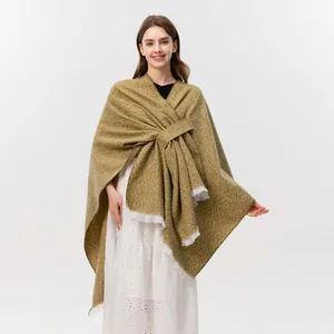 Detailaufnahme von senfgelbem Strickschal mit Fransen und stilvollem Knotendetail