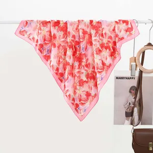 Dettaglio di sciarpa in seta con stampa floreale acquerello rosso e bordi rosa