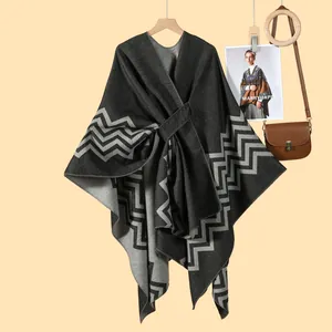 Detailed view of dark grey knitted shawl with geometric wave pattern and waist belt