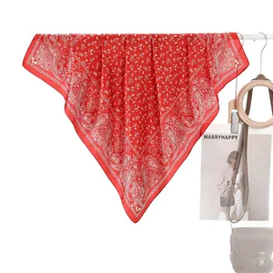 Pañuelo de seda rojo con estampado paisley para mujer colgado con accesorios de moda