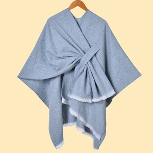 Detail der übergroßen Schleife und Fransenkante an dem gewebten Poncho für Damen