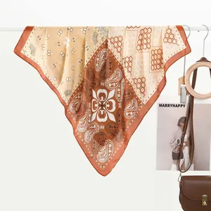 Vintage paisley silk scarf for women in earthy tones hung on a white rack