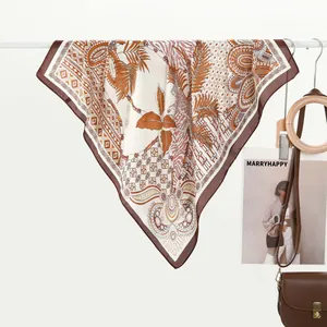 Detailed close-up of a printed silk scarf with earth-tone tropical palm leaf and leopard patterns