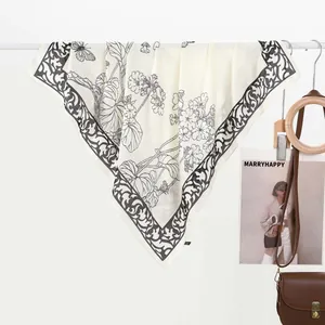 Detailed close-up of ivory silk scarf showing ink-wash flower and butterfly prints
