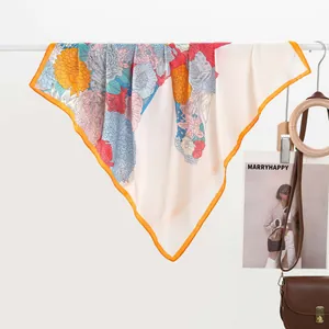 Detail of silk scarf with multi-color floral print and orange rolled edges on satin fabric
