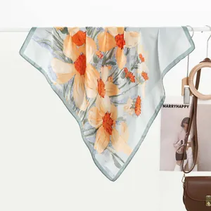 Detailed view of lightweight silk-like scarf with artistic lotus print and mint green edges