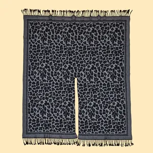 Detailed macro view of classic leopard print knit shawl with black fringe tassels