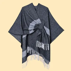 Close-up of knit shawl texture featuring dark grey stripes and white fringe details