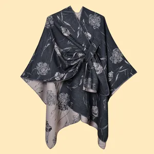 Dettaglio del motivo jacquard a rose e del nodo laterale sullo scialle mantella grigio