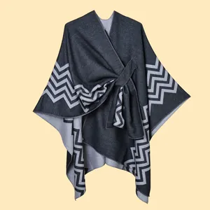Detail of dark grey knit shawl with white wave pattern edge and textured fabric finish
