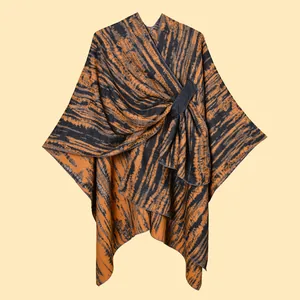 Detail of orange and grey knit shawl with abstract stripes and front loop buckle closure