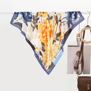 Detail of silk scarf with ink lotus floral print draped on white bar for styling