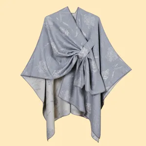 Dettaglio dello scialle grigio argento in maglia con rose jacquard e nodo a fiocco