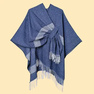 Detailed texture of blue knit shawl with white stripes and long fringe tassels
