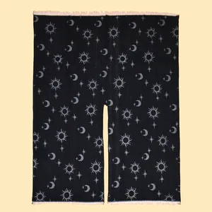 Detail of black shawl featuring silver astrology patterns with sun and moon fringe edges
