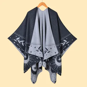 Detail of grey fringe poncho with celestial patterns and soft cashmere-like texture