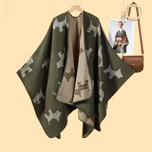 Green and beige knitted poncho featuring Scottish Terrier patterns in a warm lifestyle setting
