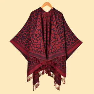 Macro view of red and black leopard print poncho with dense fringe trim detail