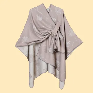 Dettaglio dello scialle in maglia jacquard rosa con elegante design reversibile rosa e beige