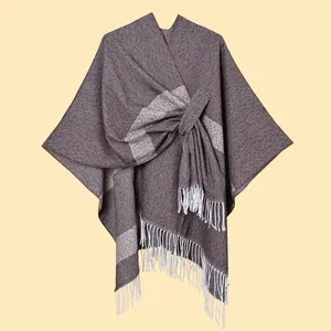 Detailed texture of dark brown knit shawl with white fringe and knotted front design