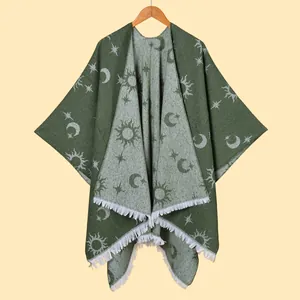 Detail of dark green knit shawl featuring grey sun and moon jacquard with white fringe