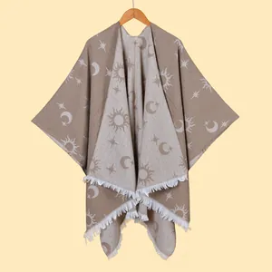 Detail of the sun and moon jacquard pattern on a thick knitted shawl with tassels