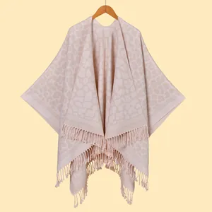 Close-up of pink leopard print knit poncho with soft cashmere-like texture and fringed hem