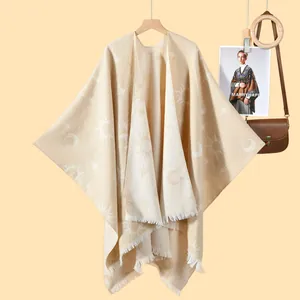 Bohemian beige knit poncho with sun and moon jacquard pattern and fringe trim