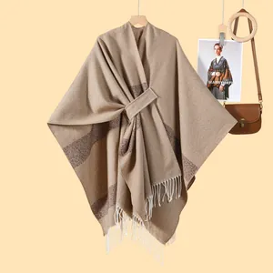 Detail of knit shawl with brown stripes, white fringe, and front tie strap closure