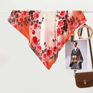 Elegant silk scarf with red roses and orange gradient edge displayed on a hanger