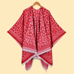 Close-up of vibrant red leopard print shawl with elegant white fringe tassel edges