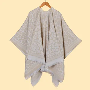 Close-up of leopard print knit shawl featuring elegant fringe trim and textured finish