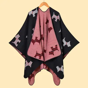 Detail of red and black reversible knit poncho showing thick texture and dog pattern