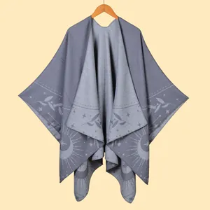 Detailed knit pattern featuring celestial sun and moon motifs on a grey tassel poncho