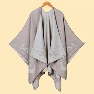 Detail of grey fringe poncho featuring sun, moon, and star astrological patterns