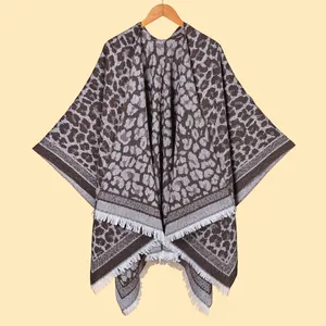 Detailed knit texture of classic leopard print shawl with elegant white fringe trim