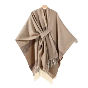Brown and beige striped shawl poncho with white tassels and a front tie closure