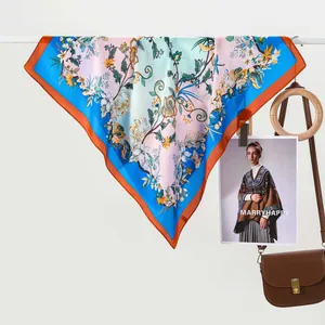 Floral print silk scarf with birds and pastel patterns featuring a bright blue border