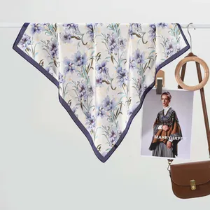 Carré de soie élégant à motif floral et bordure violette suspendu sur barre
