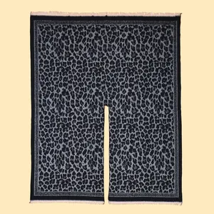 Detail of classic leopard print shawl featuring soft knit fabric and tassel trim
