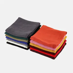 Gros plan de tours de cou en tricot empilés montrant la texture côtelée et 12 coloris variés