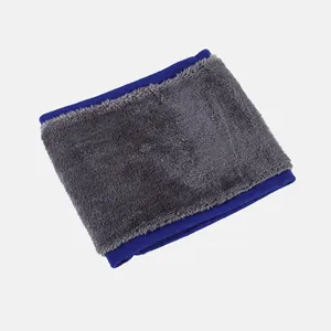 Détail d'un tour de cou en fausse fourrure grise avec bordure en tricot bleu