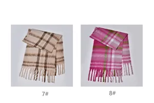 Detail of soft checkered scarves in beige brown and pink green with fringe trim