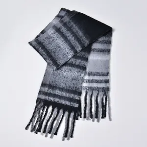 Detail of grey gradient checkered scarf featuring thick loop yarn and fringe edges