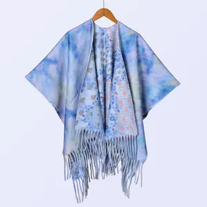 Detail von Blumenmustern und Fransen an einem dicken, doppelseitigen Poncho im Ink-Stil