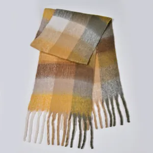 Detail of colorful plaid scarf showing thick textured knit and long tassel trim
