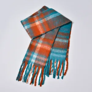Close-up of thick brushed plaid scarf featuring orange and blue grid with soft fringes