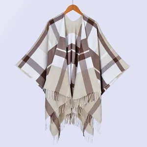 Close-up of soft plaid fabric texture and fine white tassel fringe on the shawl cape