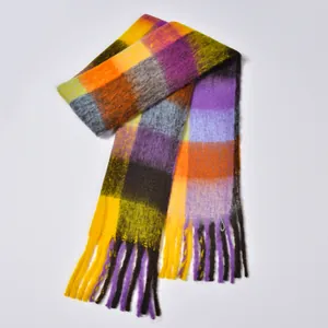 Macro detail of rainbow plaid scarf showing fluffy texture and long colorful tassels